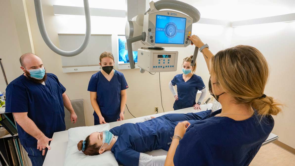 A team of rad tech students uses an X-ray machine